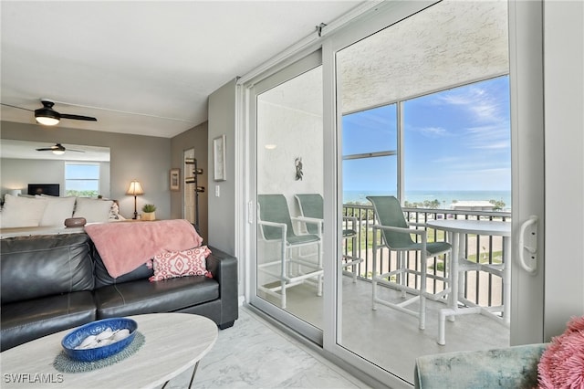 5600 Bonita Beach Rd Unit 4-605, Bonita Springs, FL 34134 - living area with marble finish floors, a ceiling fan, a wall of windows, and a water view