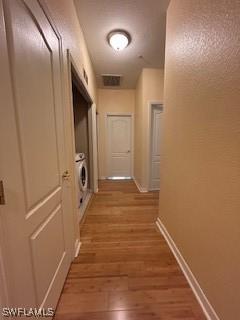 4400 Lazio Way Unit 201, Fort Myers, FL 33901 - hallway featuring light wood-style flooring and washer / dryer