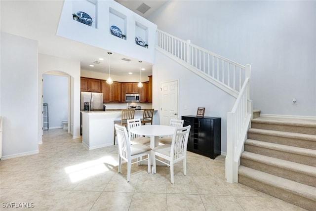 11758 Izarra Way Unit 7703, Fort Myers, FL 33912 - dining area featuring arched walkways, stairs, light tile patterned floors, a high ceiling, and recessed lighting