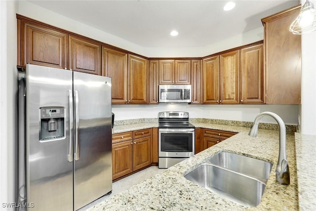 11758 Izarra Way Unit 7703, Fort Myers, FL 33912 - kitchen featuring stainless steel appliances, brown cabinets, light stone countertops, and recessed lighting