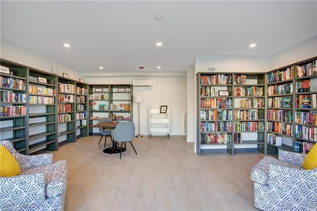 25710 Hickory Blvd Unit A 202, Bonita Springs, FL 34134 - living area featuring wall of books, recessed lighting, wood finished floors, and an AC wall unit