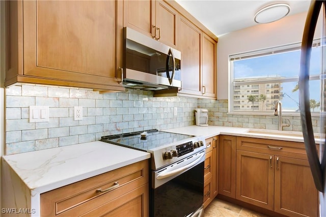 25710 Hickory Blvd Unit A 202, Bonita Springs, FL 34134 - kitchen with stainless steel appliances, tasteful backsplash, and brown cabinetry