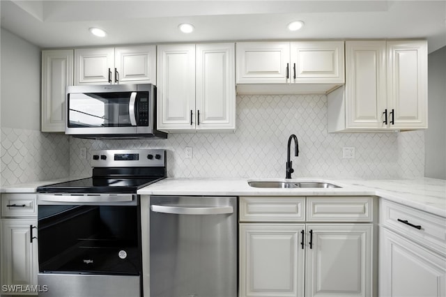 16001 Dublin Cir Unit 103, Fort Myers, FL 33908 - kitchen with stainless steel appliances, light stone counters, decorative backsplash, white cabinets, and recessed lighting