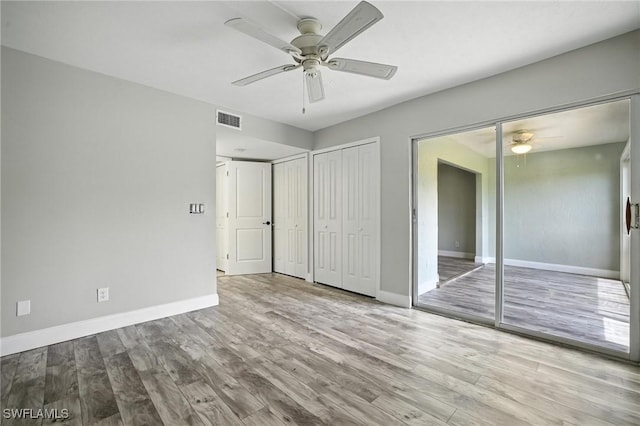 16001 Dublin Cir Unit 103, Fort Myers, FL 33908 - unfurnished bedroom featuring multiple closets, wood finished floors, and ceiling fan