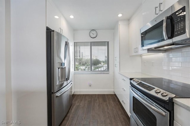 10682 Gulf Shore Dr Unit C302, Naples, FL 34108 - kitchen with appliances with stainless steel finishes, white cabinets, light countertops, dark wood finished floors, and backsplash