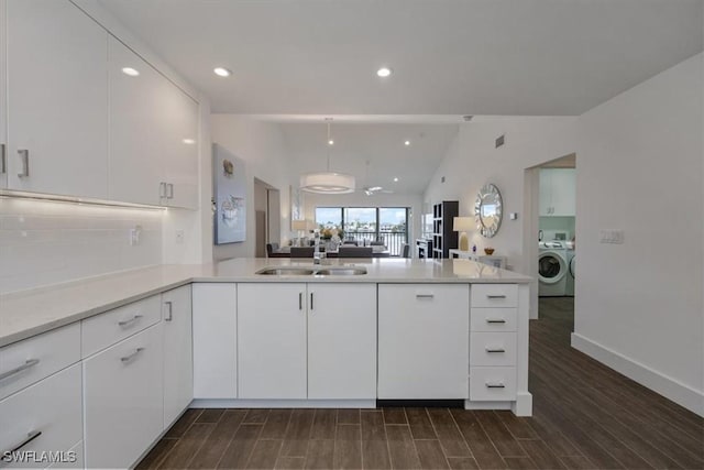10682 Gulf Shore Dr Unit C302, Naples, FL 34108 - kitchen with washer / clothes dryer, open floor plan, a peninsula, white cabinetry, and light countertops