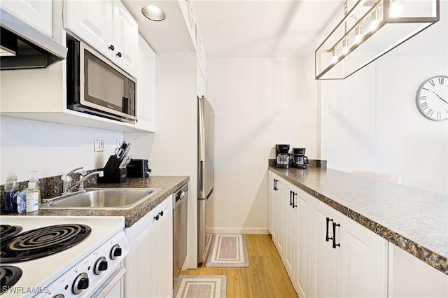 8771 Estero Blvd Unit 607, Fort Myers Beach, FL 33931 - kitchen with custom exhaust hood, appliances with stainless steel finishes, light wood-style flooring, white cabinets, and dark countertops