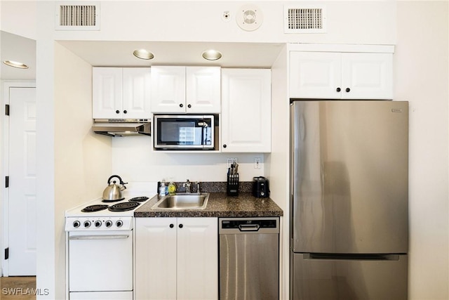 8771 Estero Blvd Unit 607, Fort Myers Beach, FL 33931 - kitchen featuring stainless steel appliances, under cabinet range hood, dark countertops, and white cabinets