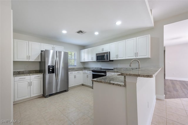 2790 Randall Blvd, Naples, FL 34120 - kitchen with stainless steel appliances, a peninsula, stone counters, white cabinets, and recessed lighting