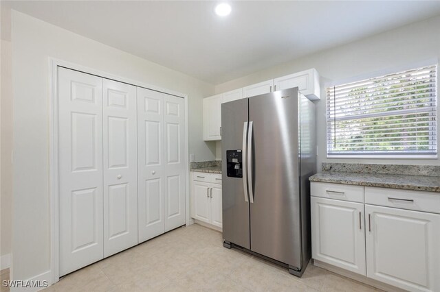 2790 Randall Blvd, Naples, FL 34120 - kitchen featuring stainless steel fridge, white cabinets, and light stone countertops