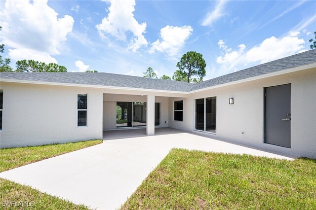 2790 Randall Blvd, Naples, FL 34120 - back of property featuring stucco siding, a patio, and a lawn