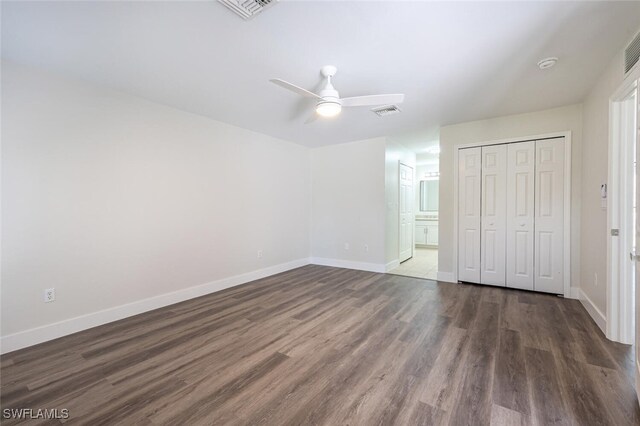 2790 Randall Blvd, Naples, FL 34120 - unfurnished bedroom featuring dark wood-type flooring, a closet, connected bathroom, and a ceiling fan