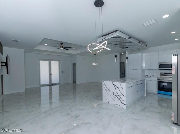 3103 13th St SW, Lehigh Acres, FL 33976 - kitchen with appliances with stainless steel finishes, white cabinets, a tray ceiling, modern cabinets, and open floor plan
