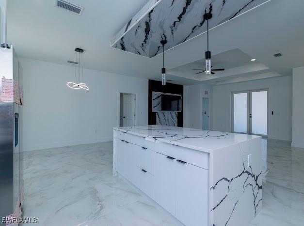 3103 13th St SW, Lehigh Acres, FL 33976 - kitchen featuring a large island, open floor plan, white cabinets, pendant lighting, and light marble finish floors