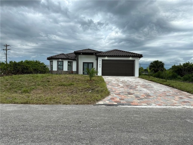 3103 13th St SW, Lehigh Acres, FL 33976 - view of front of house featuring a garage, decorative driveway, stucco siding, and a tile roof