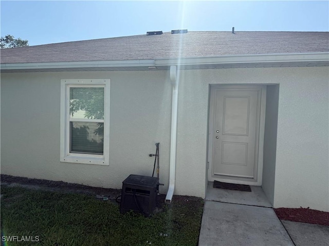 9069 Aegean Cir, Lehigh Acres, FL 33936 - entrance to property featuring stucco siding and a shingled roof