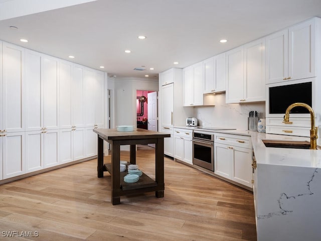 8440 Abbington Cir Unit D22, Naples, FL 34108 - kitchen featuring stainless steel oven, white cabinetry, light wood-type flooring, recessed lighting, and electric stovetop