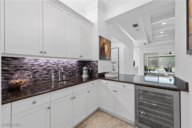 28617 Sicily Loop, Bonita Springs, FL 34135 - kitchen with beverage cooler, dark stone countertops, decorative backsplash, a raised ceiling, and white cabinetry