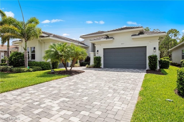 28617 Sicily Loop, Bonita Springs, FL 34135 - view of front of house with decorative driveway, an attached garage, a front yard, a tile roof, and stucco siding