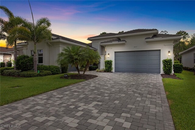 28617 Sicily Loop, Bonita Springs, FL 34135 - view of front of house with decorative driveway, a front yard, a garage, stucco siding, and a tiled roof