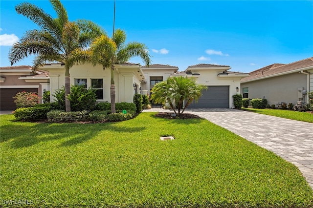 28617 Sicily Loop, Bonita Springs, FL 34135 - mediterranean / spanish house featuring an attached garage, stucco siding, decorative driveway, and a front yard