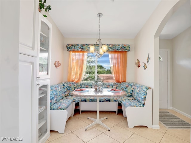 6790 Beach Resort Dr Unit 14, Naples, FL 34114 - tiled dining space with breakfast area, a chandelier, and arched walkways