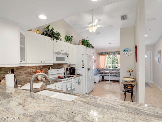 6790 Beach Resort Dr Unit 14, Naples, FL 34114 - kitchen featuring white appliances, light tile patterned floors, light stone counters, tasteful backsplash, and vaulted ceiling