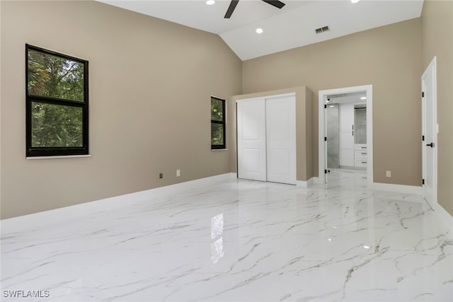 431 1st St NW, Naples, FL 34120 - unfurnished bedroom with light marble finish flooring, recessed lighting, high vaulted ceiling, a closet, and ensuite bath