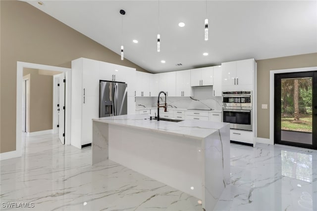 431 1st St NW, Naples, FL 34120 - kitchen with stainless steel appliances, light marble finish floors, white cabinets, lofted ceiling, and hanging light fixtures