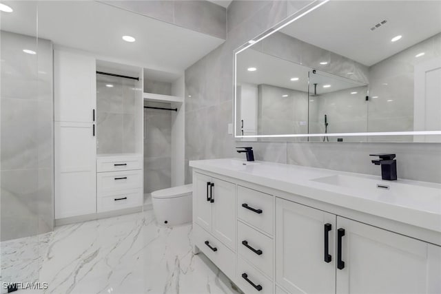 431 1st St NW, Naples, FL 34120 - bathroom with marble tiled floors, double vanity, tile walls, walk in shower, and recessed lighting