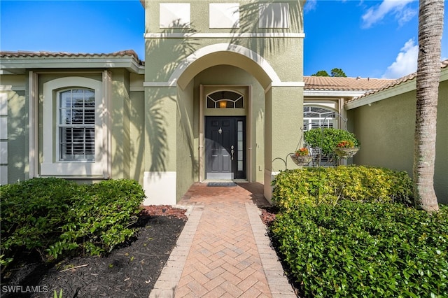 12977 Turtle Cove Trl, North Fort Myers, FL 33903 - doorway to property with stucco siding and a tiled roof