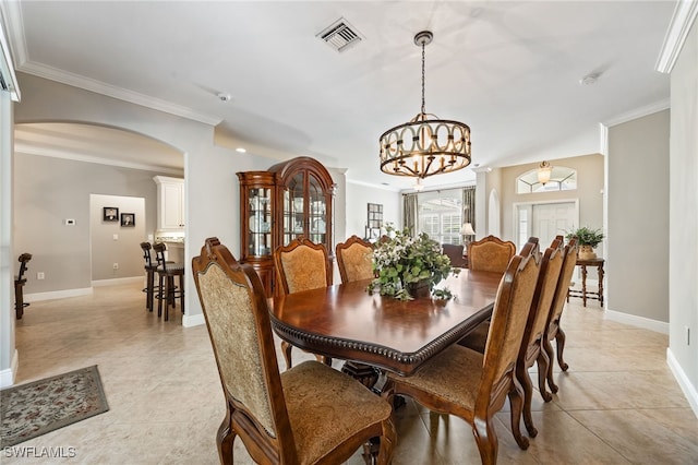12977 Turtle Cove Trl, North Fort Myers, FL 33903 - dining area featuring arched walkways, a chandelier, light tile patterned floors, and ornamental molding