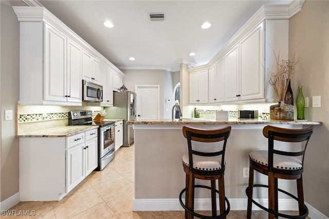 12977 Turtle Cove Trl, North Fort Myers, FL 33903 - kitchen with stainless steel appliances, a peninsula, backsplash, light stone counters, and recessed lighting