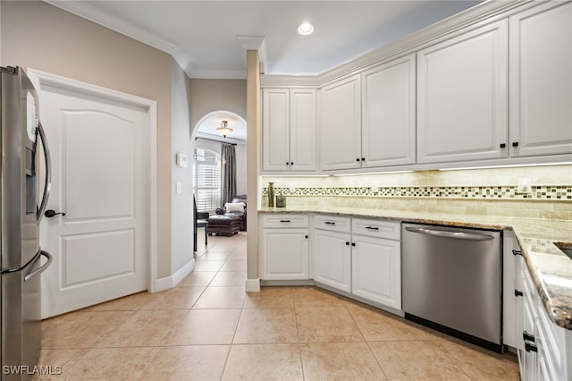 12977 Turtle Cove Trl, North Fort Myers, FL 33903 - kitchen with appliances with stainless steel finishes, decorative backsplash, ornamental molding, arched walkways, and white cabinetry