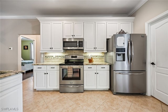 12977 Turtle Cove Trl, North Fort Myers, FL 33903 - kitchen featuring stainless steel appliances, ornamental molding, tasteful backsplash, white cabinets, and light stone counters