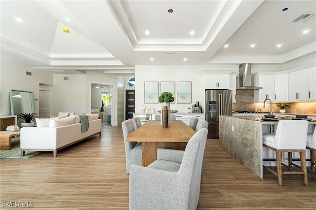 5203 Starfish Ave, Naples, FL 34103 - dining space featuring a tray ceiling, recessed lighting, and light wood finished floors