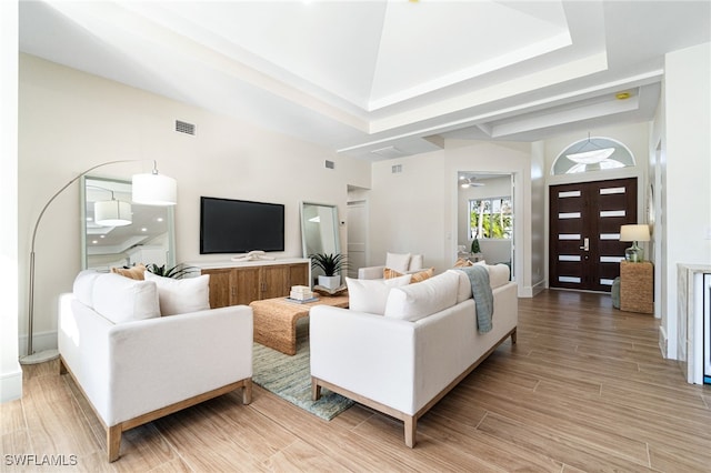 5203 Starfish Ave, Naples, FL 34103 - living room with light wood finished floors, a ceiling fan, a towering ceiling, and a tray ceiling
