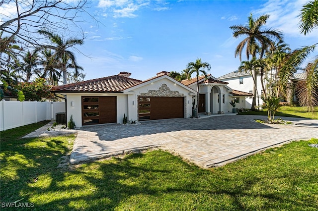 5203 Starfish Ave, Naples, FL 34103 - mediterranean / spanish house featuring an attached garage, stucco siding, a tile roof, and decorative driveway