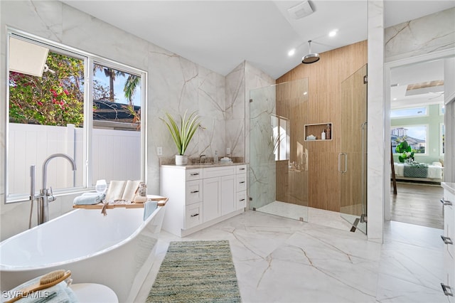 5203 Starfish Ave, Naples, FL 34103 - bathroom featuring a shower stall, a freestanding tub, marble tiled floors, vanity, and vaulted ceiling