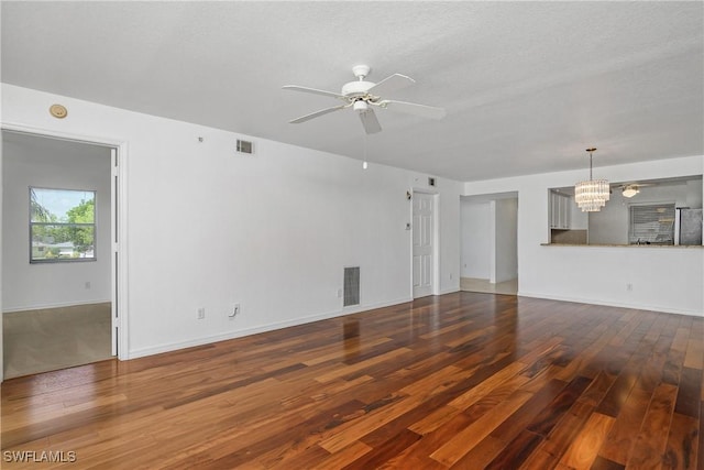 9650 Victoria Ln Unit 201B, Naples, FL 34109 - unfurnished living room featuring wood finished floors, a chandelier, and a ceiling fan