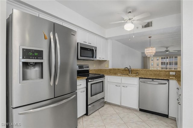 9650 Victoria Ln Unit 201B, Naples, FL 34109 - kitchen with stainless steel appliances, ceiling fan, white cabinets, a chandelier, and stone counters