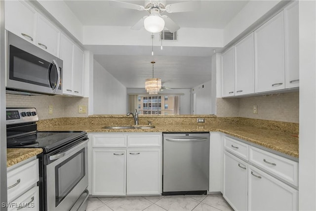 9650 Victoria Ln Unit 201B, Naples, FL 34109 - kitchen with stainless steel appliances, a ceiling fan, white cabinetry, backsplash, and light stone counters