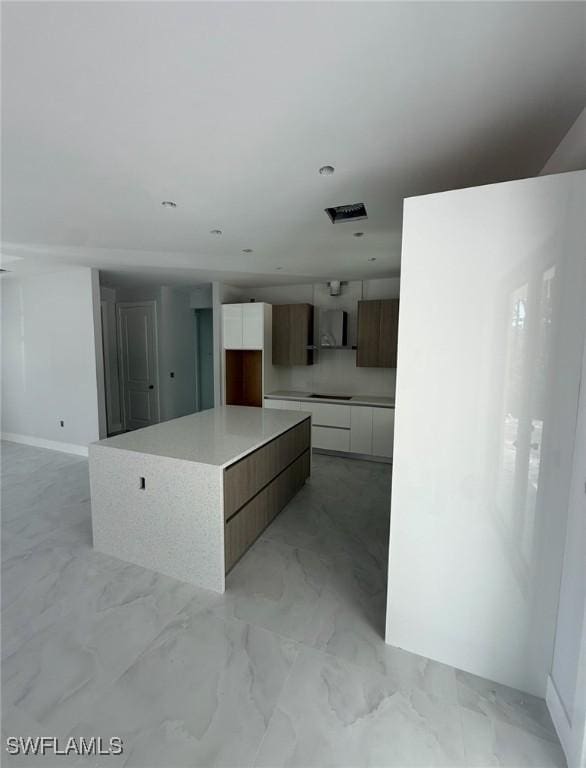 3722 29th Ave NE, Naples, FL 34120 - kitchen with modern cabinets, white cabinetry, light marble finish flooring, cooktop, and a large island
