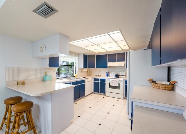 113 Picardy Ct, Naples, FL 34112 - kitchen featuring white appliances, blue cabinets, under cabinet range hood, a peninsula, and tasteful backsplash