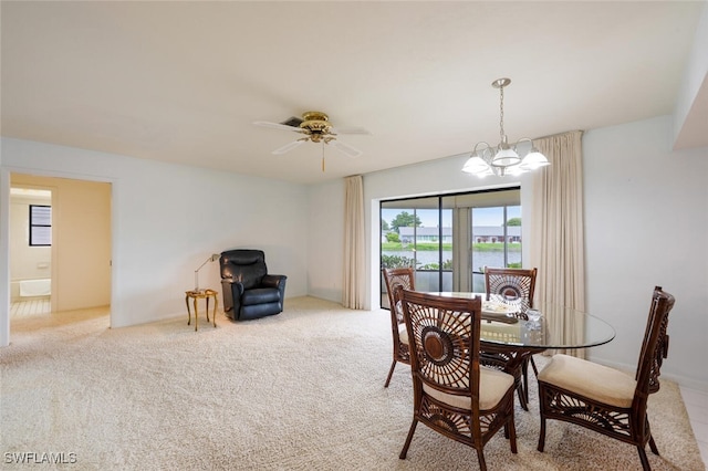 113 Picardy Ct, Naples, FL 34112 - dining room with a chandelier, a water view, a ceiling fan, and light colored carpet