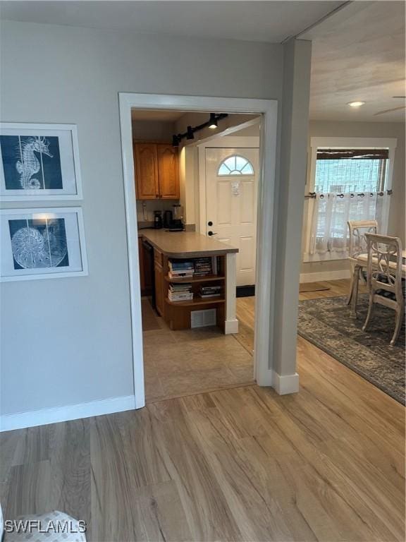 120 Bay Mar Dr, Fort Myers Beach, FL 33931 - kitchen featuring a barn door, light wood-style flooring, brown cabinetry, and light countertops