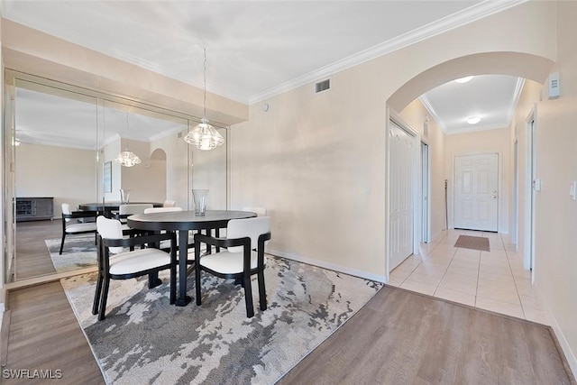 8610 Cedar Hammock Cir Unit 1223, Naples, FL 34112 - dining room featuring arched walkways, wood finished floors, and ornamental molding