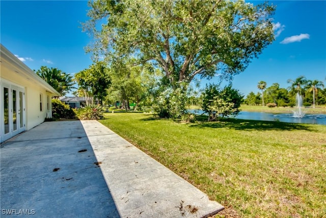 17225 Castleview Dr, North Fort Myers, FL 33917 - view of green lawn with a water view, french doors, and a patio area