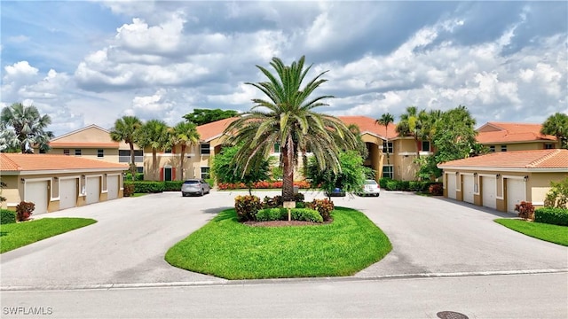 6770 Huntington Lakes Cir Unit 203, Naples, FL 34119 - mediterranean / spanish-style home featuring community garages, a residential view, and stucco siding