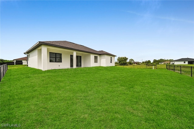 542 Raintree St E, Lehigh Acres, FL 33974 - back of property with a fenced backyard and stucco siding